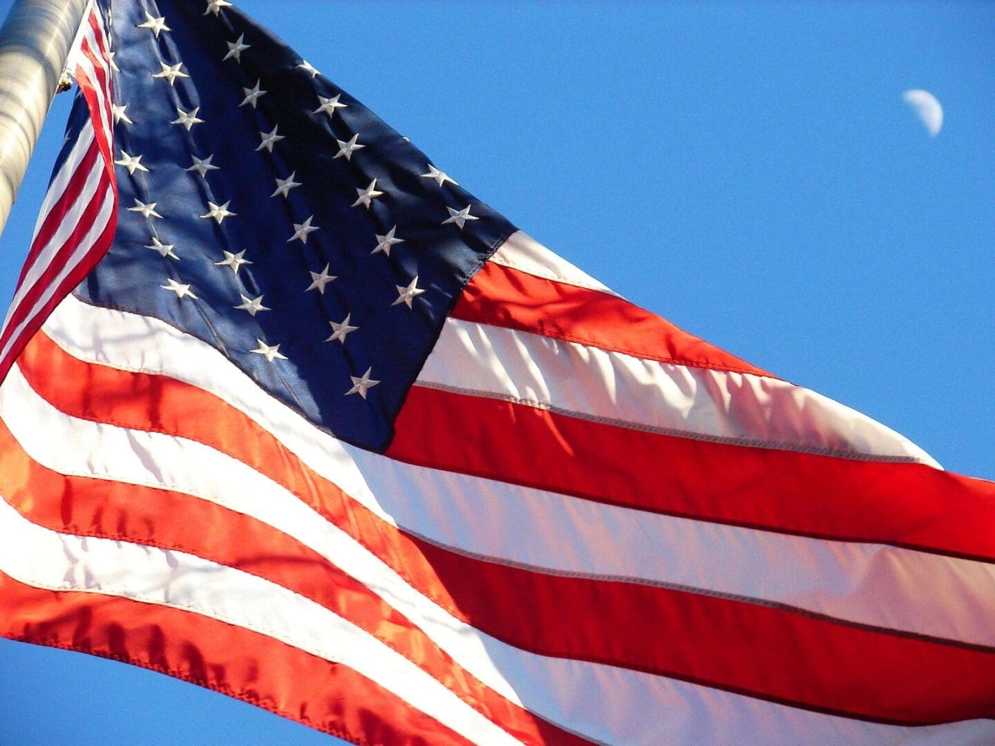 A close up of the american flag flying in the sky